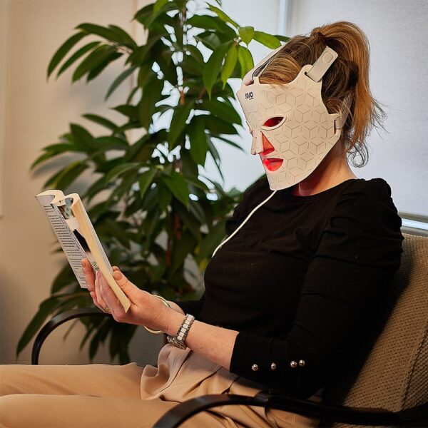 rojo led facial mask whilst reading a book