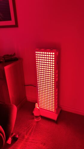 refine series red light therapy device against the wall